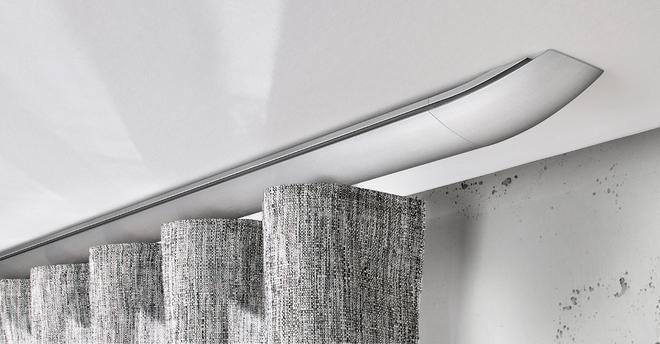Moderne deckenmontierte Gardinenschiene mit grauen Stoffvorhängen